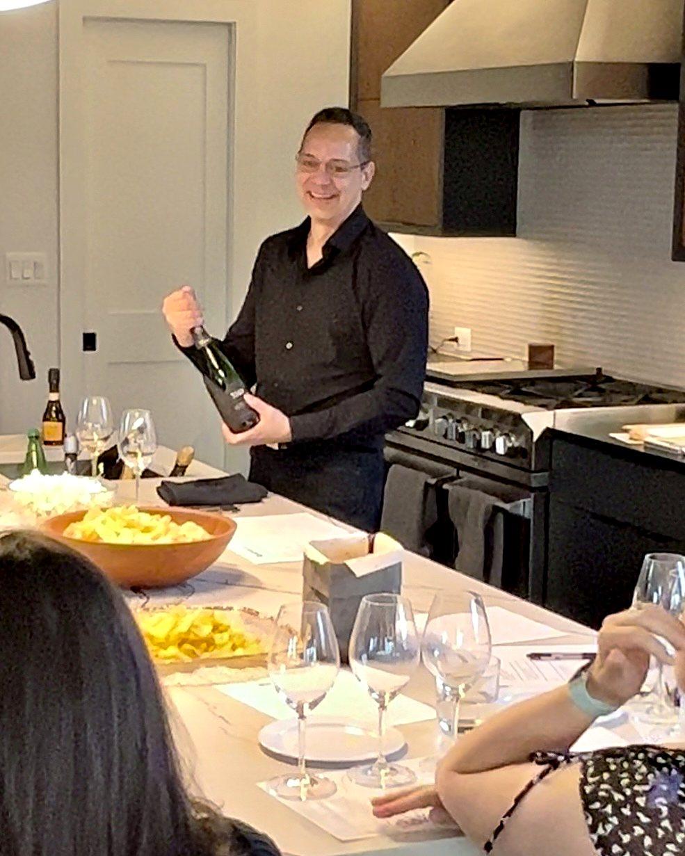 Lieven holding a bottle of grower Champagne at a private tasting in a home kitchen